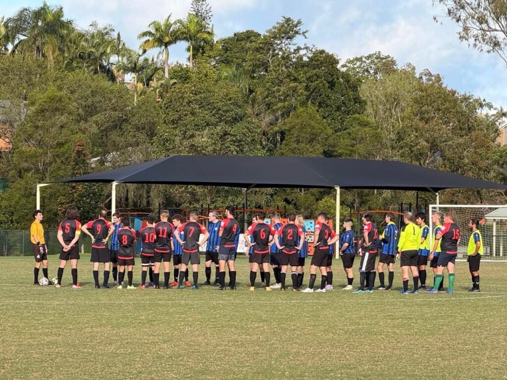 Holy Cross FC players shaking hands with the opposing team before kick-off